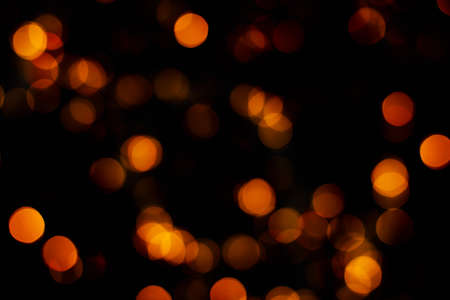Blurred abstract gold glitter texture, defocused christmas lights on black background. Holiday...