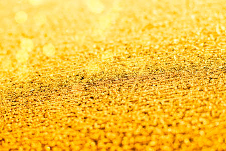 Texture of sparkling first cold ice. Snowy backdrop in gold color. Winter background for design. Abstraction in nature.の写真素材