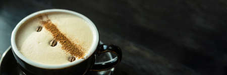 Horizontal banner with cup of coffee with beautiful art from coffee beans on a wooden dark background. Copy space.の写真素材