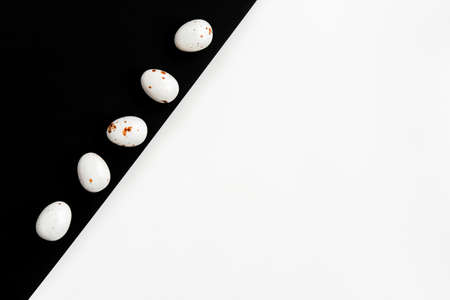 Easter minimal composition with multicolored eggs on the white black background. Easter concept. Copy space, flat lay.の写真素材