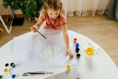 Young cute girl spending a time drawing using online lessons on laptop. Distance learning, online education.の写真素材