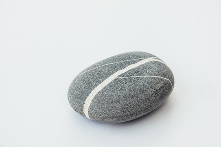One sea stone of a round form on the light background. Top view of a smooth pebble.の写真素材