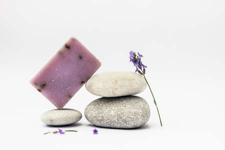 Lavender soap on the pedestal from sea stones on light background.