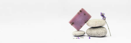 Lavender soap on the pedestal from sea stones on light background. Banner.の写真素材
