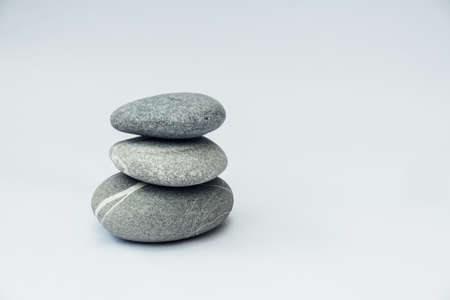 Stone cairn on light background, stones tower, simple poise stones. Purity harmony and Balance Concept.の写真素材