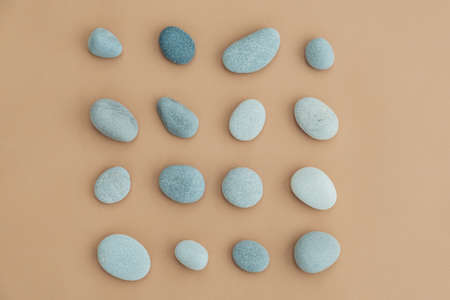 Set of sea stones of a round form on beige background. Top view of a collection of smooth pebbles.の写真素材