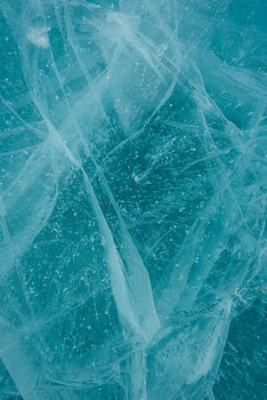 Texture of beautiful blue ice with cracks and air bubbles in the frozen lake. Winter nature background.の写真素材