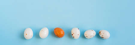 Easter minimal composition with multicolored eggs on the blue background. Easter concept. Copy...