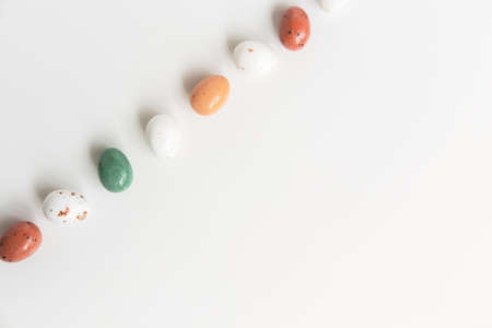 Easter minimal composition with multicolored eggs on the white background. Easter concept. Copy space, flat lay.の写真素材