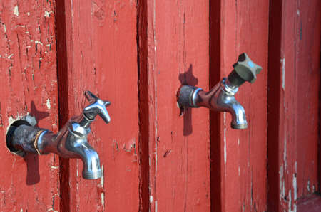 Red wall and two tapsの写真素材