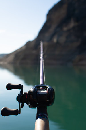 vertical photo of a fishing rod catches the water