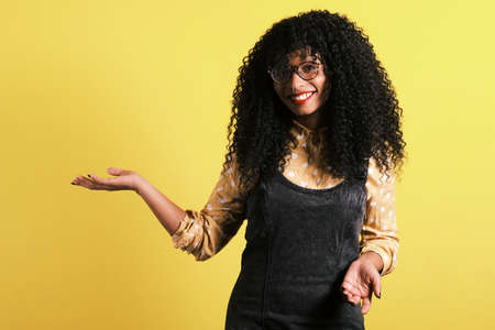 afro american woman with yellow background with copy space for product placementの写真素材
