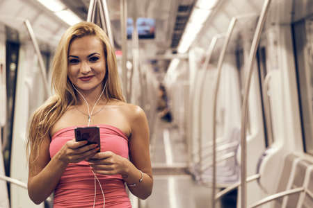 a young beautiful woman at the metro (subway) using her mobile phone in Barcelona, Spain - Transport Conceptの写真素材
