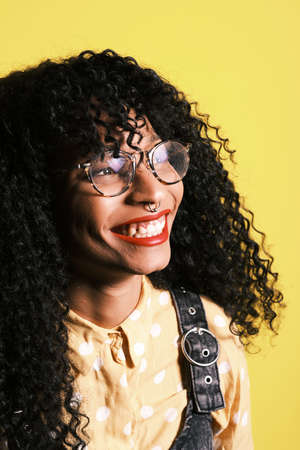 young african american with afro hairstyle, eyeglasses and yellow backgroundの写真素材