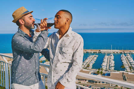 a gay couple with a glass of wineの写真素材