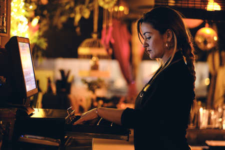 a beautiful young woman at the desk in a restaurantの写真素材