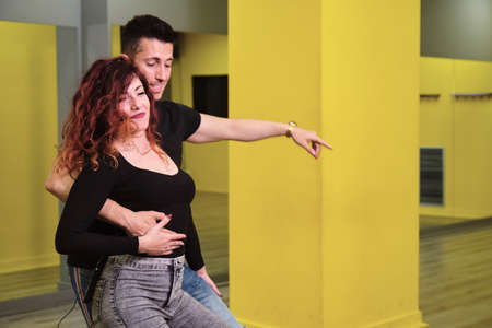 A young woman and a man teaching Salsa and Bachata
