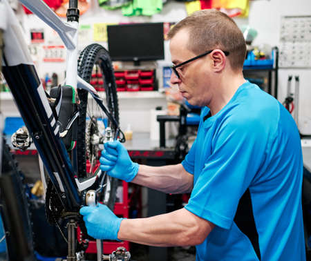 a man repairs a bike in his small business workshopの写真素材