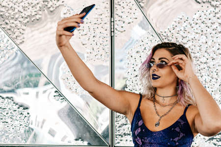 a young alternative girl using her mobile phone with violet dress and lips - Lifestyle conceptの写真素材