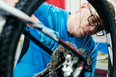 a man repairs a bike in his small business workshopの写真素材