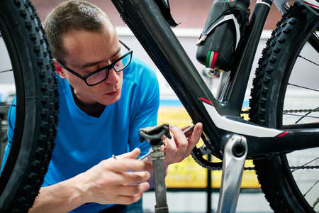 a man repairs a bike in his small business workshopの写真素材