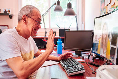 Man working from home having online videoconference on laptopの写真素材