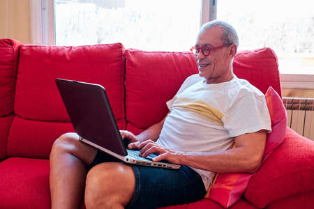 old grey hair man working at home with his laptopの写真素材