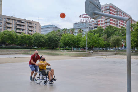 disabled sport man in wheelchair in action while playing basketball at a basketball courtの写真素材