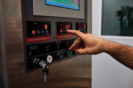 worker in a factory press button from a machine