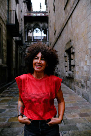 mature woman in front of Pont del Bisbe in Gothic Quarter, Barcelona