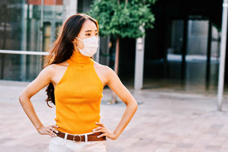 Young asian girl wearing face mask in urban environmentの写真素材