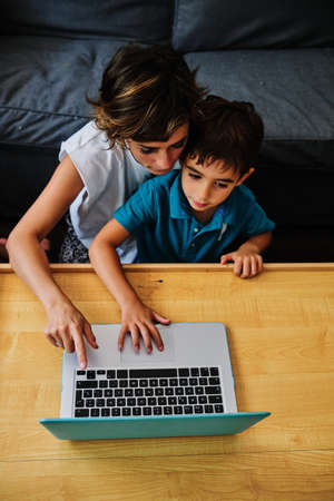 a mother teaching his son with the help of a computer - stay at home conceptの写真素材