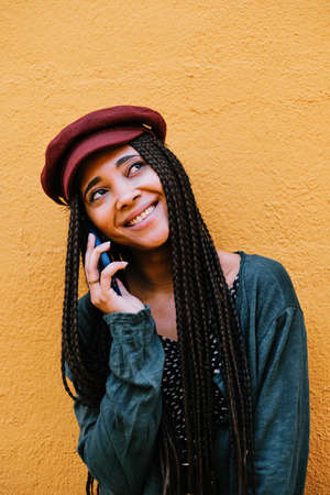 black woman with braids making phone call with smartphoneの写真素材