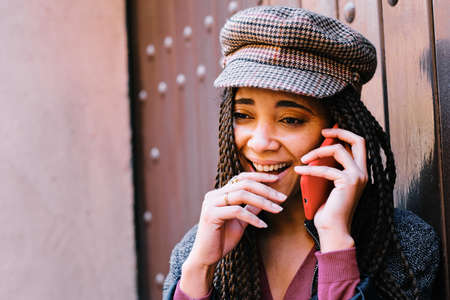 black woman with braids making phone call with smartphone