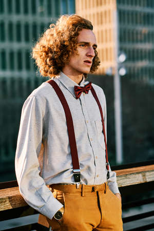 Young stylish man standing outdoors.