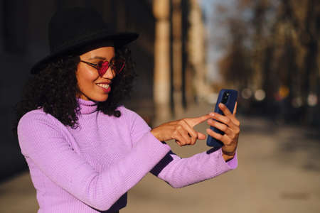 Woman with finger on mobile phone screen.の写真素材