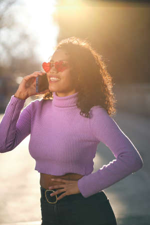 Young woman talking on the phone outdoors.
