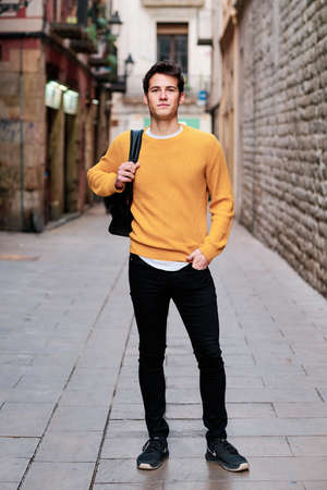 Young man standing outdoors on the street.