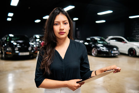 young latin saleswoman selling luxury carsの写真素材