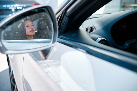 young latin woman driving a luxury carの写真素材