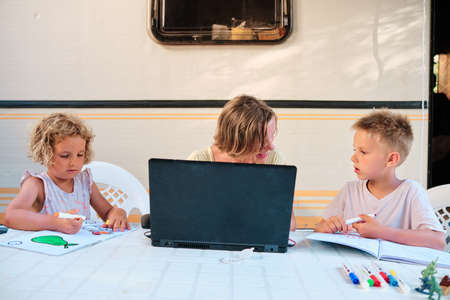 young mother working while on vacation and attending her family