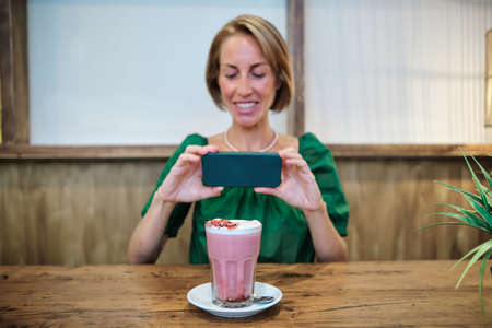 adult woman taking picture of smoothieの写真素材