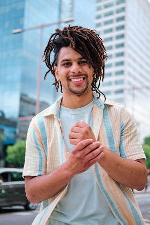 portrait of a young latin man surrounded with modern city buildings