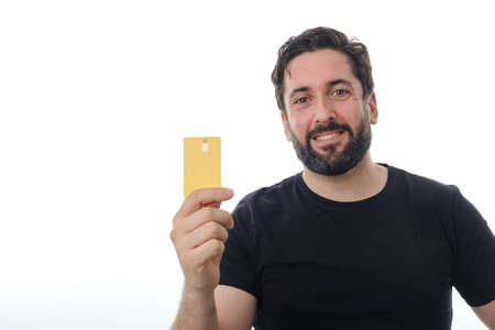 Man holding a credit card while standing over an isolated background.の写真素材