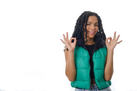 Positive woman showing OK gesture with both hands while standing on isolated background.の写真素材
