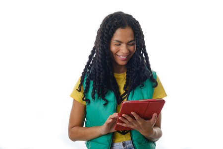 Latin woman in headphones smiling while using a digital tablet over an isolated background.の写真素材