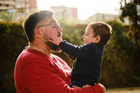 Happy little boy and his father enjoy good time together outdoors.の写真素材
