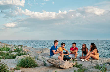 group of young people at sunset at the beachの写真素材