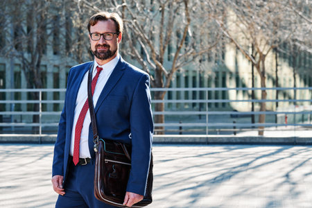 Portrait of a businessman with a suit and a bag in the streetの写真素材