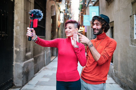 Two people recording an online video with a mobile outdoors